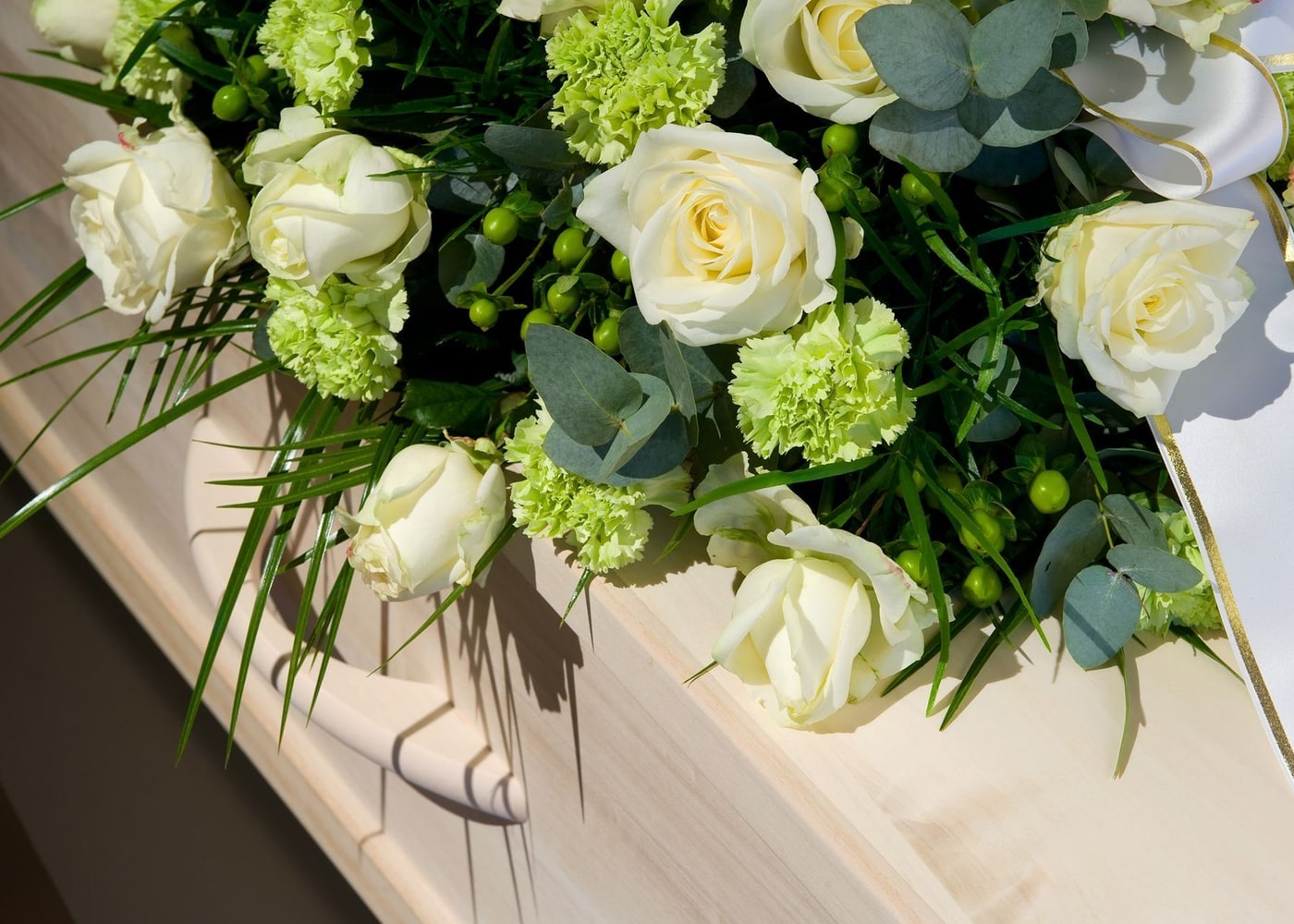 Rose bianche e fiori verdi composti sul coperchio di un cofano